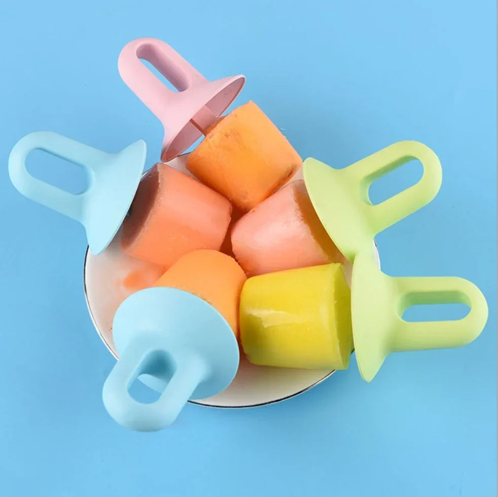 Five colorful silicone popsicle molds in pastel blue, pink, and light green, shown with several frozen popsicles in orange and yellow on a small white plate against a solid blue background.