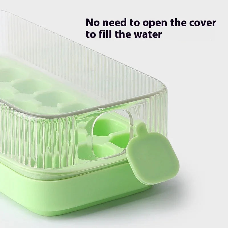 A light green silicone ice cube tray with a clear ribbed lid and a small matching silicone tab, shown on a white background with the text 'No need to open the cover to fill the water'.
