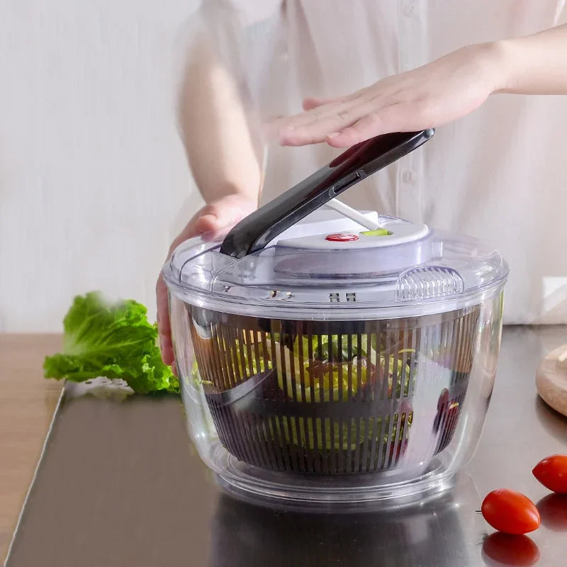 Person using a salad spinner with vegetables on a kitchen counter