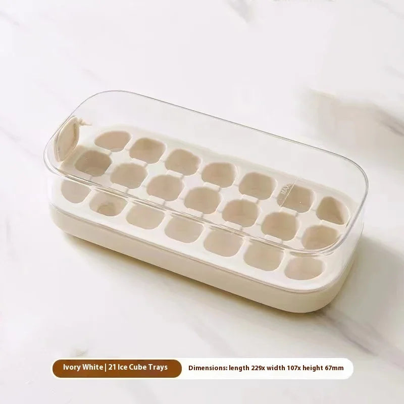 An ivory white 21-piece ice cube tray with a clear plastic lid, resting on a light marble surface. Text at the bottom reads 'Ivory White | 21 Ice Cube Trays' with dimensions listed below.
