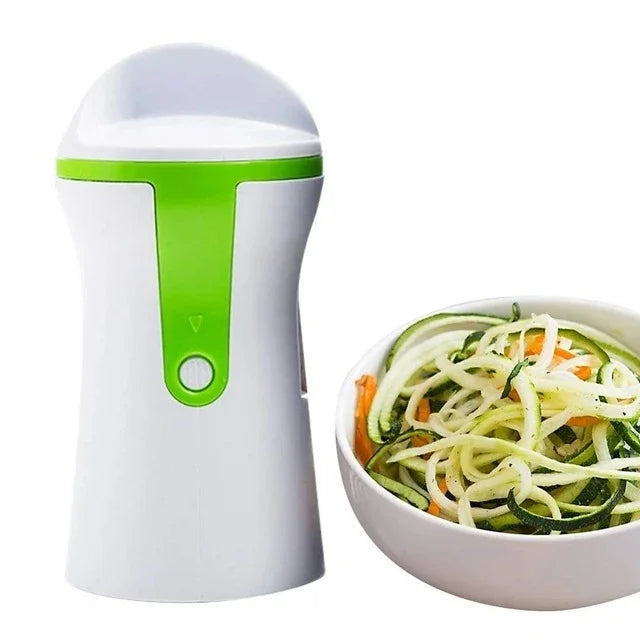 Handheld spiralizer with green accents next to a bowl of spiralized vegetables on a white background
